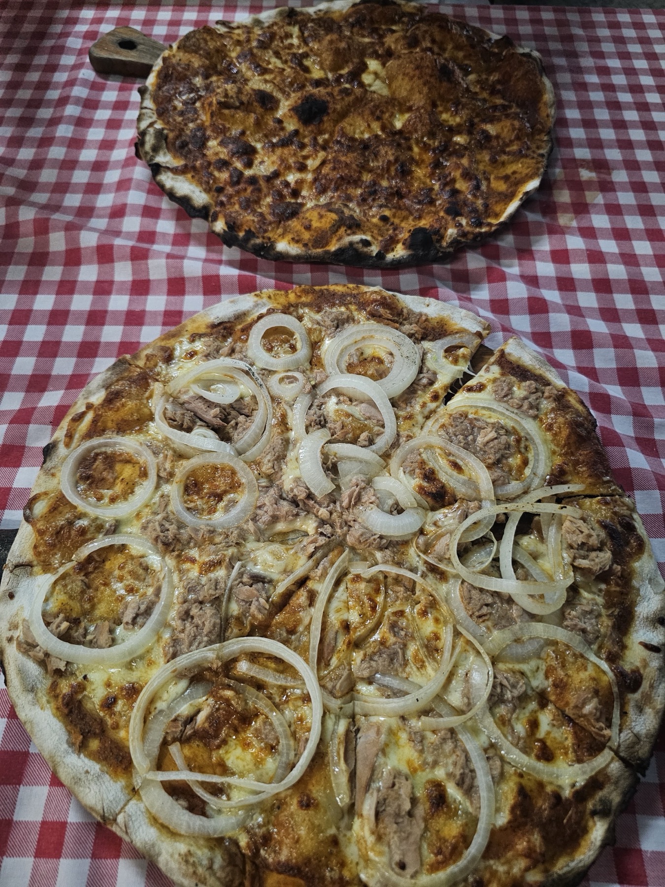Thunfisch-Zwiebel-Pizza auf rot karierter Tischdecke